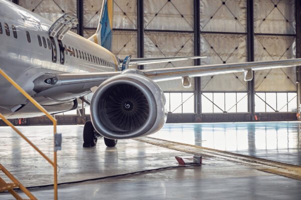 Close up image of wing with engine of commercial airplane on the scheduled technical modernization located in the airfield