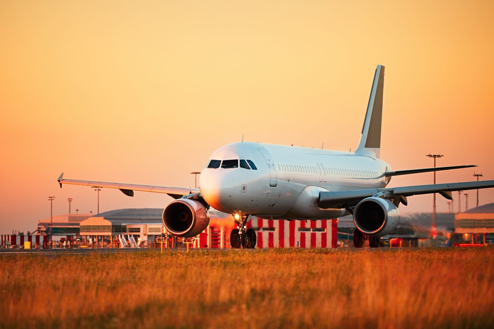 Airport at the sunset light. Airplane is taxing to the runway for take off.