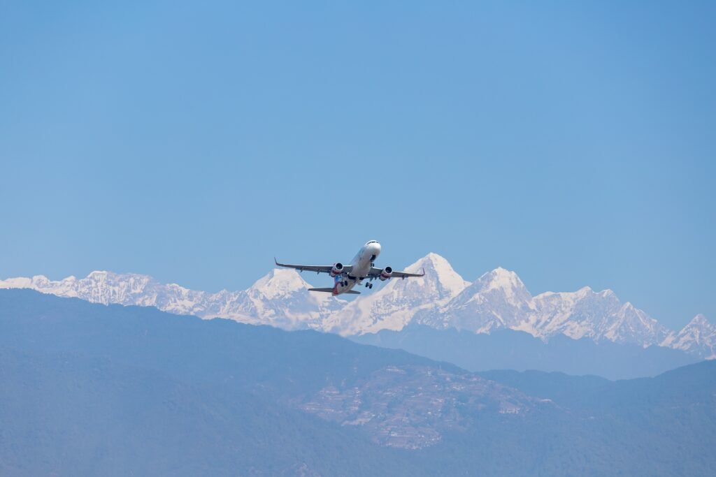 plane flying over snowy mountains.
