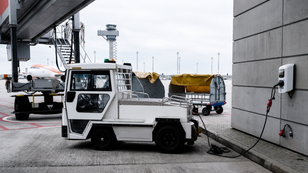 Electric airport ground vehicle charging at an airport gate. Green Aviation Jobs.