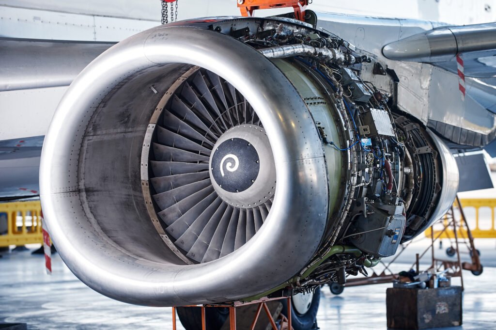 Aircraft engine servicing - opened panels of a large engine of parked aircraft. nobody. MRO Recruitment.