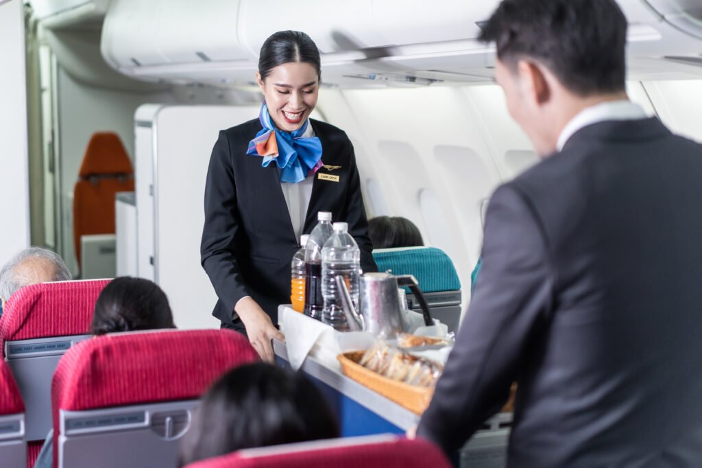 Flight attendant serving refreshments to passengers. flight attendant recruitment.