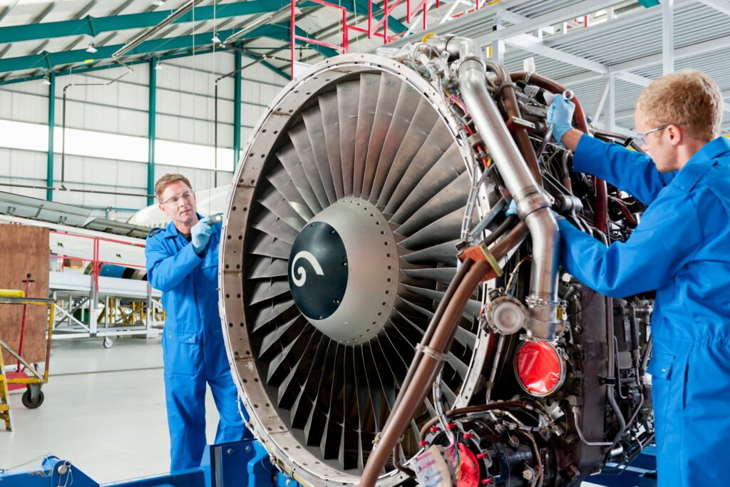 engineers-repairing-a-jet-engine-in-a-hangar. Aviation workforce gaps.