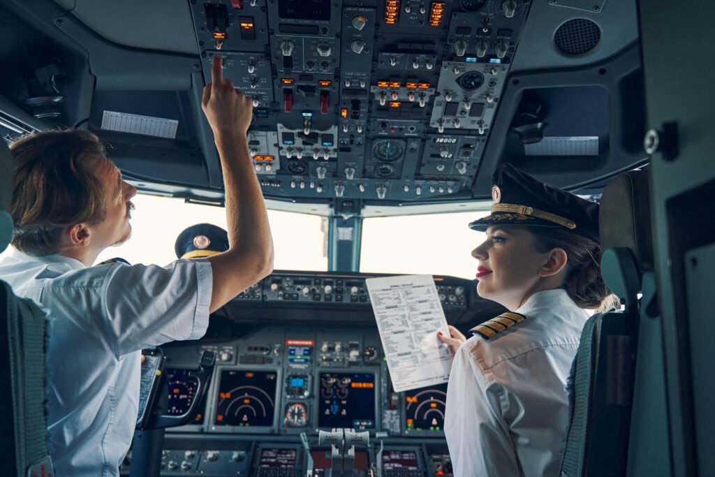 Smiling female co-pilot with a before-takeoff checklist in her hand looking at an airline captain in the cockpit. AI in aviation recruitment.